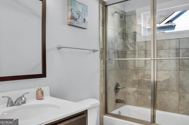 full bathroom featuring toilet, vanity, and combined bath / shower with glass door