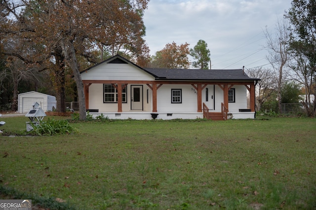 view of front of house featuring an outbuilding, a porch, a garage, and a front yard