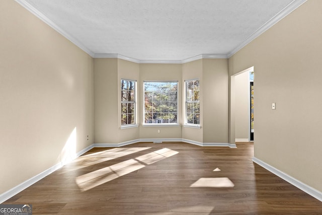 spare room with wood-type flooring, ornamental molding, and a textured ceiling