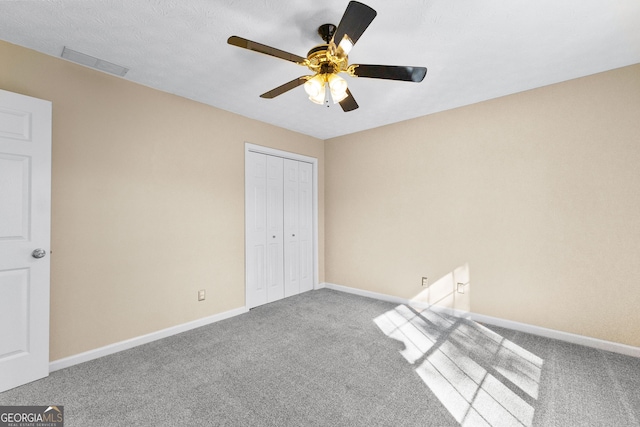 unfurnished bedroom with ceiling fan, light colored carpet, and a closet