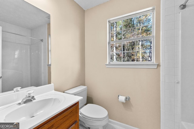 bathroom featuring toilet, vanity, a wealth of natural light, and walk in shower