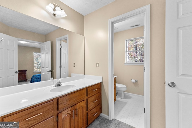 bathroom with a textured ceiling, toilet, and vanity