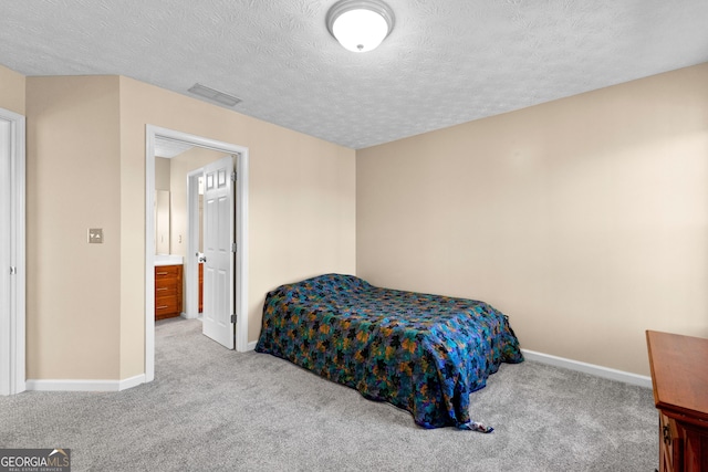 bedroom with a textured ceiling and light colored carpet