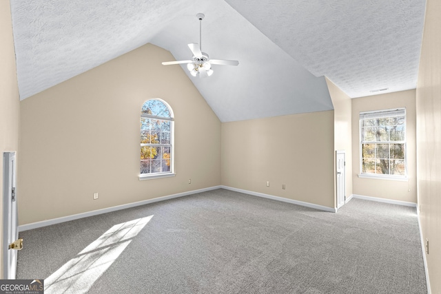 additional living space featuring ceiling fan, light colored carpet, a textured ceiling, and lofted ceiling