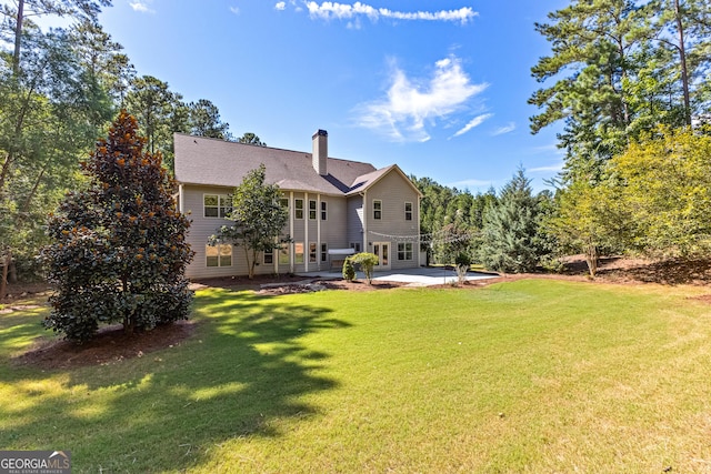 rear view of house with a lawn and a patio area