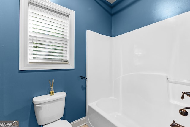 bathroom with toilet and a tub to relax in