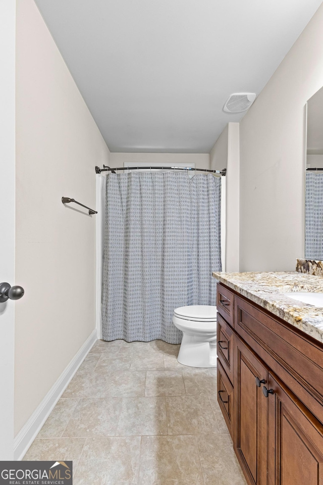 bathroom featuring tile patterned floors, vanity, toilet, and walk in shower