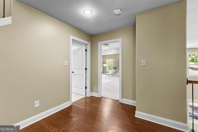 corridor with hardwood / wood-style flooring