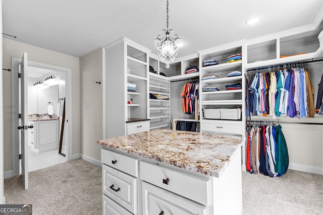 spacious closet featuring light colored carpet and a chandelier