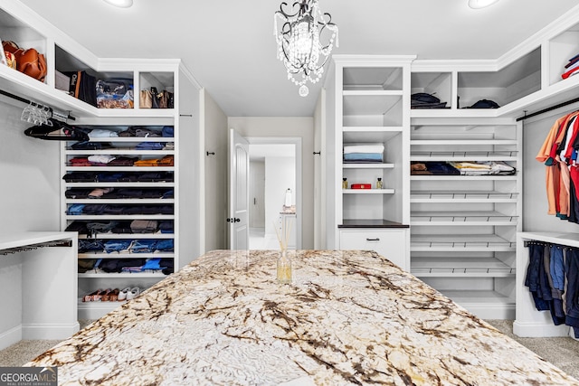 walk in closet with light carpet and a chandelier