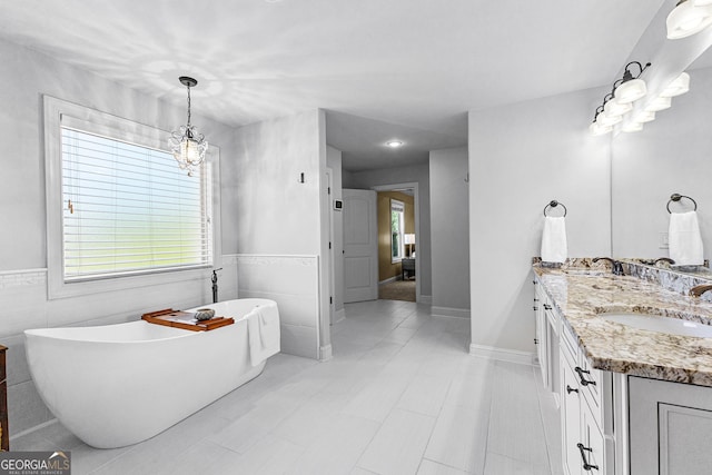 bathroom featuring a tub, vanity, and tile walls