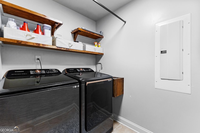 laundry area featuring electric panel, washer and clothes dryer, and light tile patterned flooring