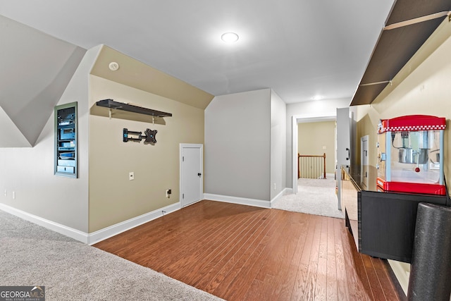 additional living space featuring vaulted ceiling and hardwood / wood-style flooring