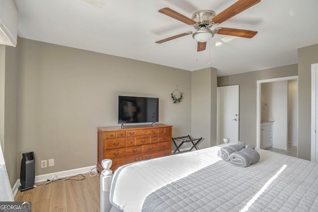 bedroom with ceiling fan, light wood-type flooring, and ensuite bath