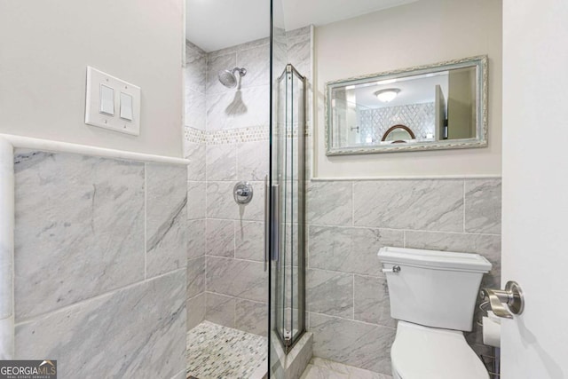 bathroom with a tile shower, tile walls, and toilet