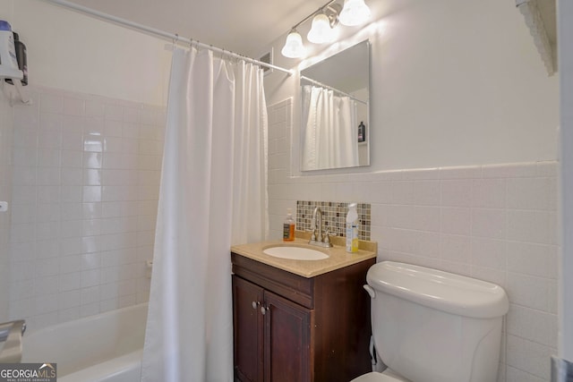 full bathroom featuring shower / bath combo, vanity, tile walls, and toilet