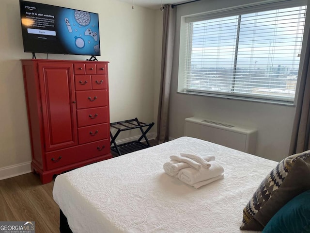 bedroom featuring dark hardwood / wood-style flooring and radiator