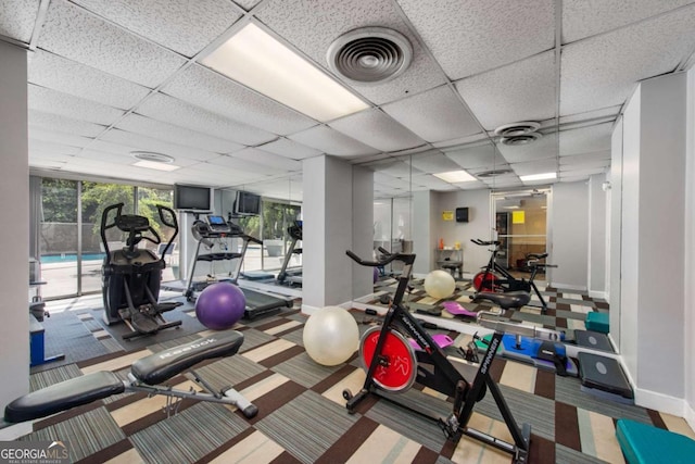 workout area with carpet floors and a drop ceiling