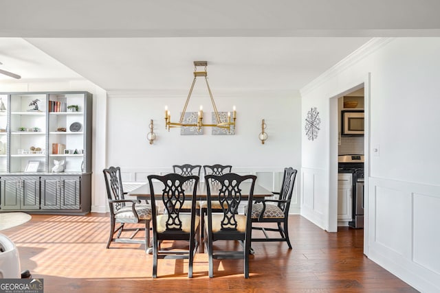 dining room with ceiling fan with notable chandelier, dark hardwood / wood-style floors, and crown molding