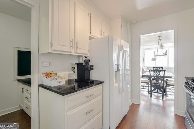 kitchen with white cabinetry, dark wood-type flooring, stainless steel range with gas stovetop, and white refrigerator with ice dispenser