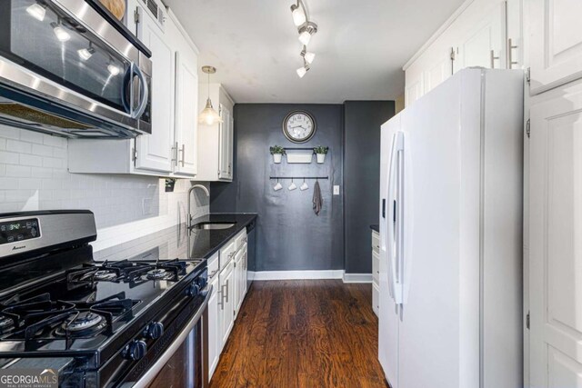 kitchen with white cabinetry, sink, dark wood-type flooring, decorative backsplash, and appliances with stainless steel finishes