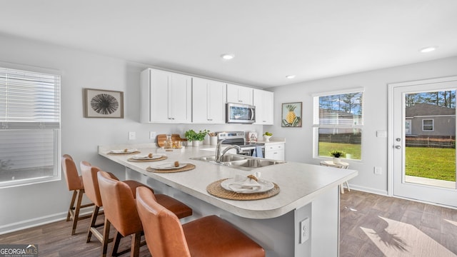 kitchen featuring appliances with stainless steel finishes, kitchen peninsula, and a breakfast bar area