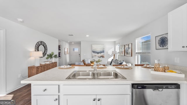 kitchen featuring sink, stainless steel dishwasher, white cabinets, and dark wood-type flooring