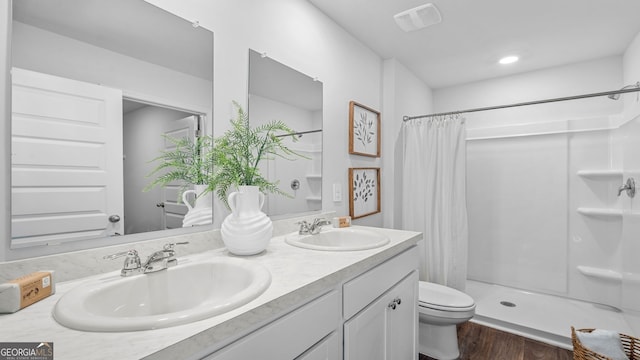 bathroom with a shower with curtain, vanity, hardwood / wood-style floors, and toilet