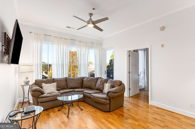 living room featuring light wood-type flooring, ceiling fan, and crown molding