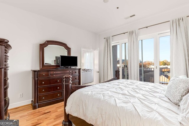 bedroom featuring light wood-type flooring and access to outside