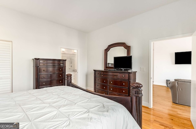 bedroom featuring ensuite bath and light hardwood / wood-style flooring