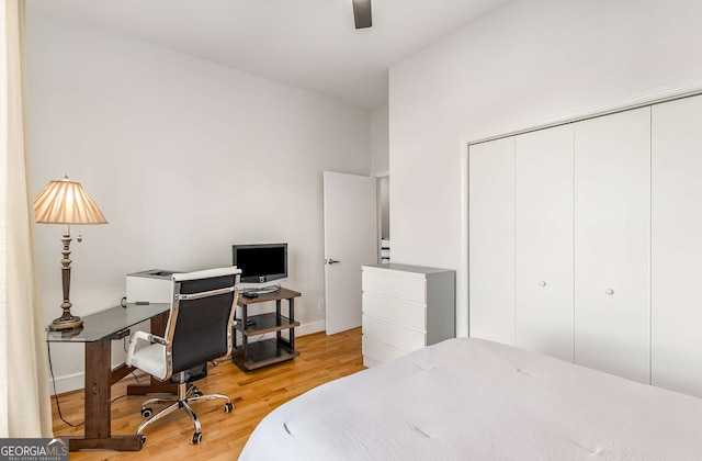 bedroom featuring ceiling fan, a closet, and light hardwood / wood-style flooring