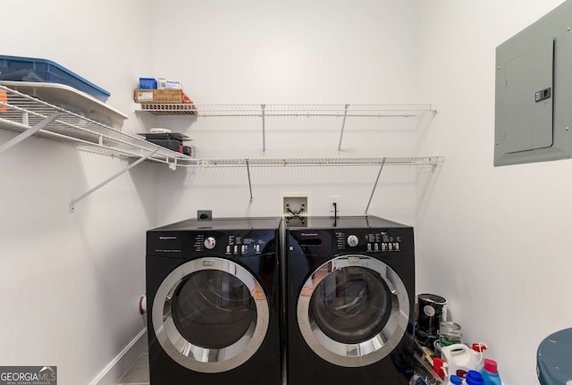 washroom with electric panel and washer and clothes dryer