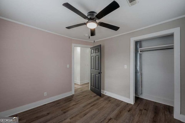 unfurnished bedroom featuring a closet, dark hardwood / wood-style floors, ceiling fan, and ornamental molding