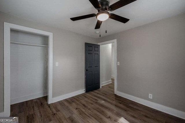 unfurnished bedroom featuring ceiling fan, dark hardwood / wood-style floors, and a closet