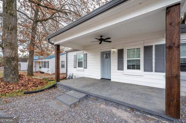 view of exterior entry with ceiling fan and a porch