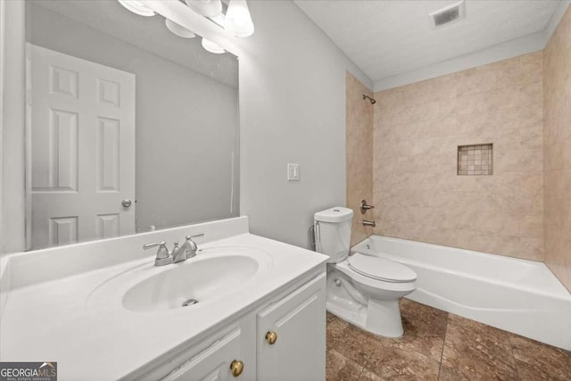 full bathroom with toilet, vanity, and tiled shower / bath