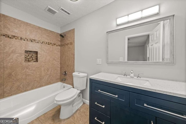 full bathroom featuring tile patterned flooring, a textured ceiling, toilet, vanity, and tiled shower / bath