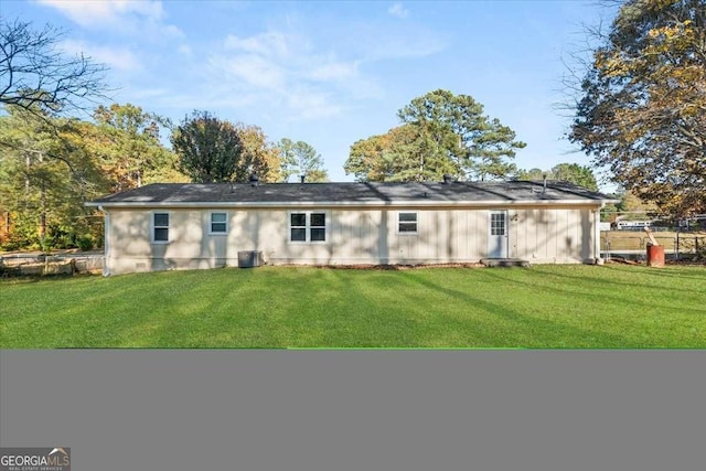 back of property with a lawn and central air condition unit