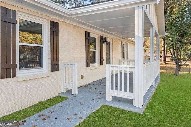 view of side of property with a porch and a lawn