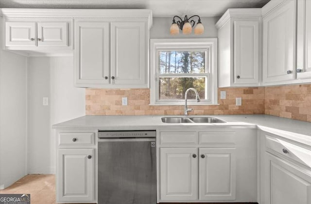 kitchen with tasteful backsplash, sink, white cabinets, and stainless steel dishwasher