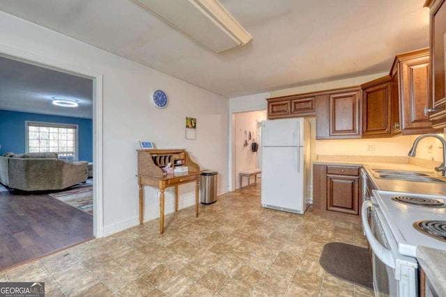 kitchen featuring sink, white appliances, and light hardwood / wood-style flooring