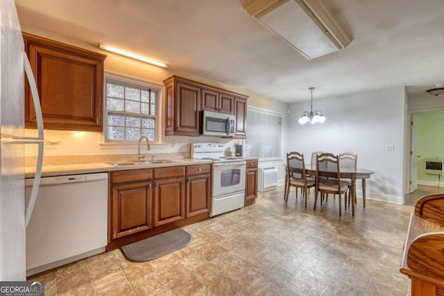 kitchen with sink, heating unit, a chandelier, pendant lighting, and white appliances