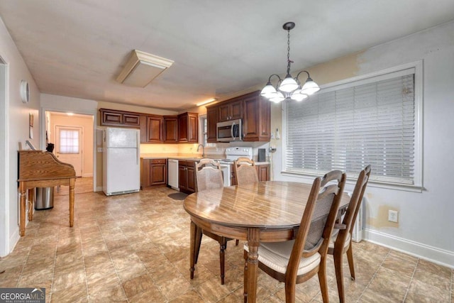 dining area featuring sink and an inviting chandelier