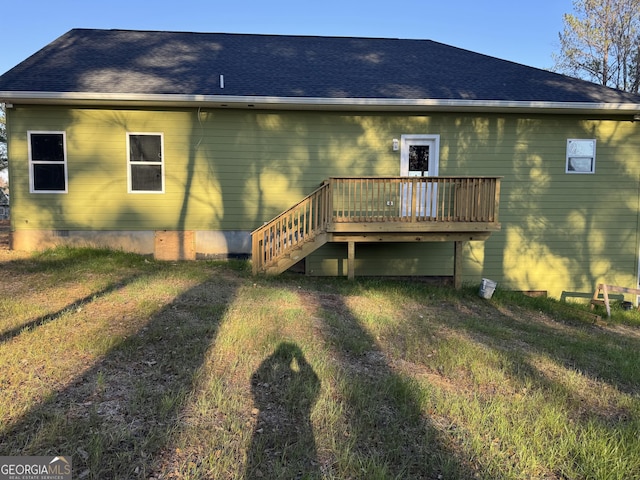 back of property featuring a lawn and a deck