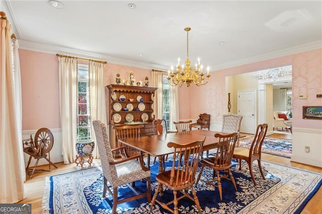 dining room with light hardwood / wood-style floors, ornamental molding, and a chandelier