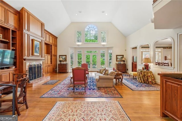 living room featuring light wood-type flooring and high vaulted ceiling