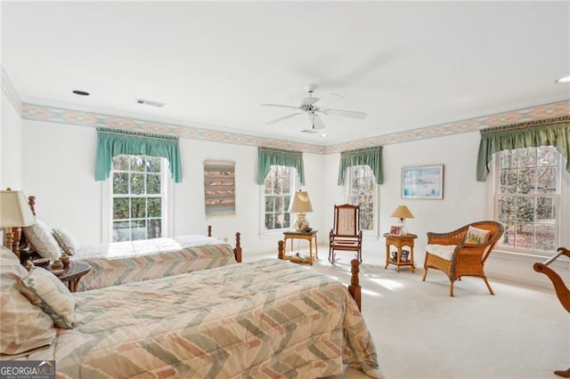 bedroom featuring light carpet, multiple windows, crown molding, and ceiling fan