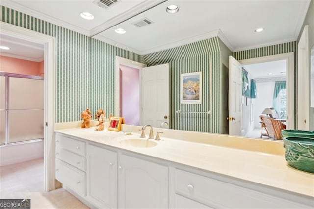 bathroom featuring crown molding, vanity, and enclosed tub / shower combo