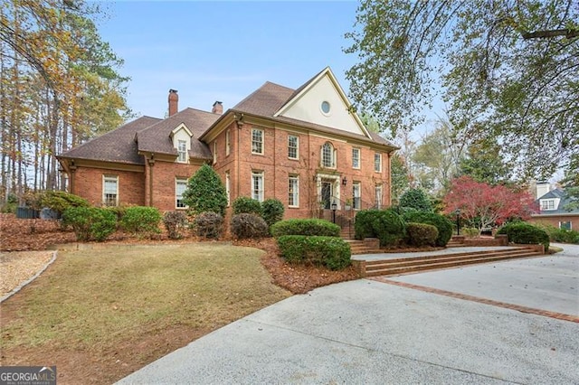 colonial inspired home with a front lawn